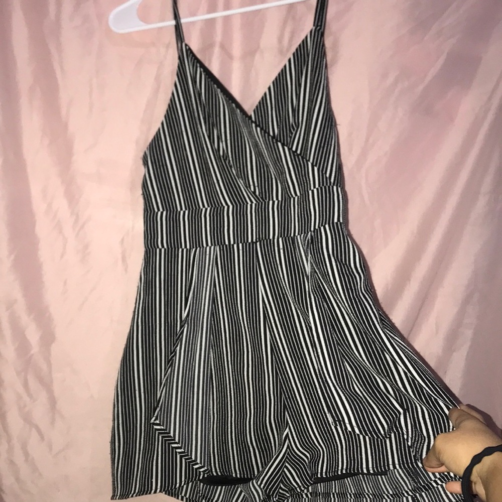 Size med. Black striped romper. Back is like a mini skirt.Has adjustable straps.